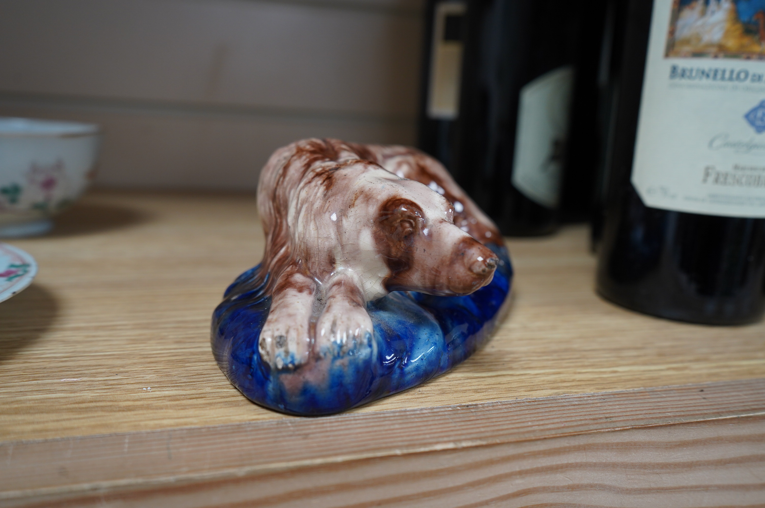 A late 19th century earthenware model of a recumbent hound, possibly Scottish, Portobello, 18.5cm wide. Condition - fair to good